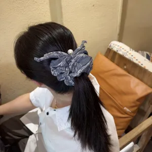 Denim blue scrunchie hair accessory detail, featuring stylish fabric and elegant pearl accent.