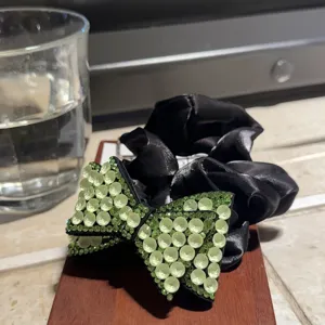 Elastico capelli fiocco strass, fermacoda raso nero, dettaglio accessorio per acconciatura.