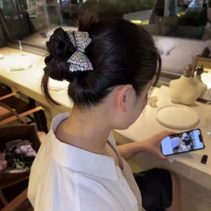 Elastico per capelli con fiocco in raso e strass, elegante accessorio nero per le acconciature.