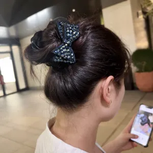 Dettaglio dell'elastico con fiocco in strass, satin delicato e cristalli blu brillanti.