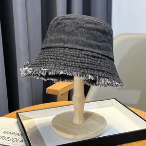 Dark grey washed denim bucket hat with distressed frayed brim for casual outdoor wear.
