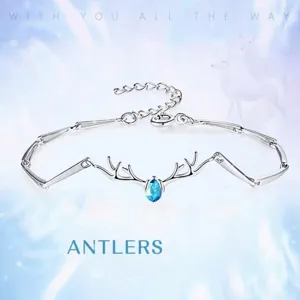 Squisito bracciale in argento con corna di cervo e pietra blu a goccia, elegante design.