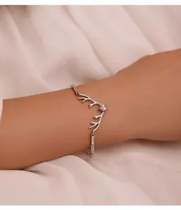 Elegante braccialetto in argento con design di corna di cervo e gemma rosa a cuore.