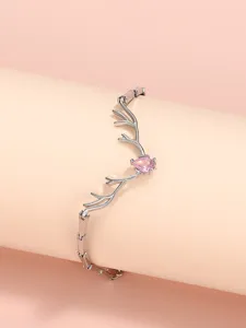 Dettaglio di bracciale in argento con corna di cervo e gemma rosa a goccia fine.
