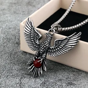 Close-up detail of vintage stainless steel eagle pendant necklace with red gemstone.