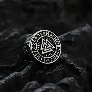 Detailed close-up view of vintage Viking rune ring featuring runes on dark rock.