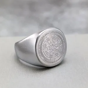 Primer plano detallado del anillo de sello de brújula de acero inoxidable vintage con acabado cepillado.