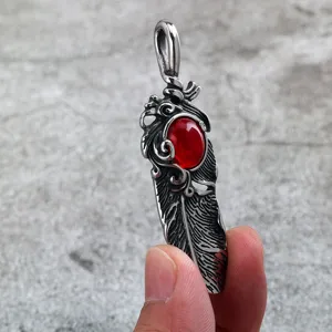 Close-up of men stainless steel feather pendant with red stone detail, retro metal jewelry design.