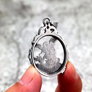 Close-up detail of vintage stainless steel archangel pendant showcasing intricate relief design.