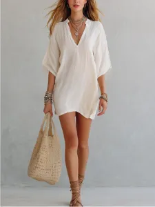 Detailed shot of the casual white v-neck loose vacation tunic top with accessories.