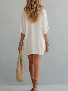 Detail view of a casual loose white V-neck tunic top, perfect for summer vacation beach wear.
