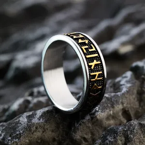 Close-up view of retro stainless steel Viking rune ring with gold and black details.