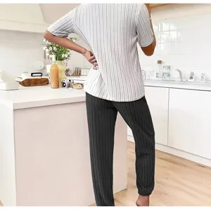 Gedetailleerd overzicht van de casual gestreepte korte mouwen top en donkere broek in keuken.