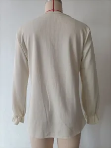 Detail view of waffle knit long sleeve top, featuring delicate ruffled cuffs and relaxed fit.
