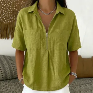 Olive green short sleeve collared V-neck zip up top detail view showcasing fabric and zipper.
