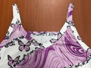 Nahaufnahme Detail des ärmellosen Damen V-Ausschnitt Tops mit Marmor und Schmetterling.