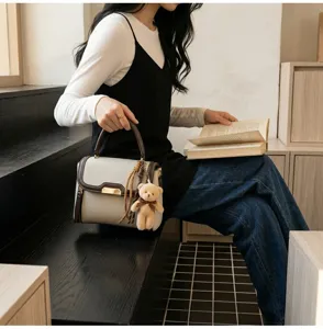 Chic retro women handbag with cute bear pendant, stylish shoulder crossbody bag detail view.