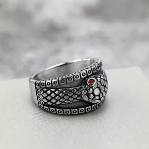 Stainless steel snake ring detail shot showing intricate scales texture and red crystal eye.