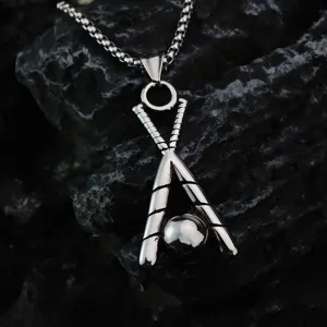 Gros plan détaillé du collier pendentif de baseball rétro en acier sur fond de roche.