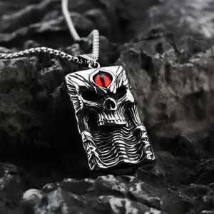 Primer plano detallado del colgante de calavera gótica de acero inoxidable con piedra roja.
