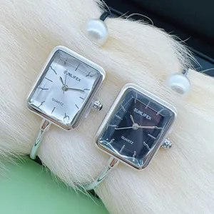 Detailansicht der Damen Quarz Armreif Uhr mit Perlen Dekor und klarem Zifferblatt.
