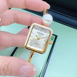 Nahaufnahme Detail der eleganten quadratischen Quarzuhr für Damen mit schickem Perlenarmband.