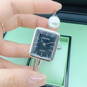 Exquisite Damenuhr mit quadratischem Zifferblatt, funkelnden Steinen und Perlenarmband.