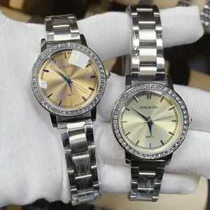 Vue détaillée d'une montre pour femme avec lunette en strass et bracelet en acier fin.