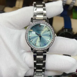Montre à quartz en acier argenté avec lunette strass et détail de cadran vert-bleu.