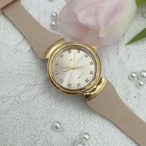 Detail view of vintage style quartz women watch with beige silicone strap and diamond markers.