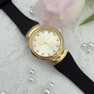 Vintage women's quartz watch with gold case, black silicone strap and crystal dial.