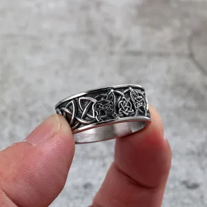 Close-up detail of vintage stainless steel ring with Viking wolf and Celtic knot design.