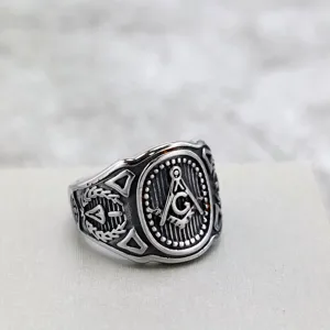 Vintage stainless steel Freemasonry men ring closeup showcasing square compass motif detail.