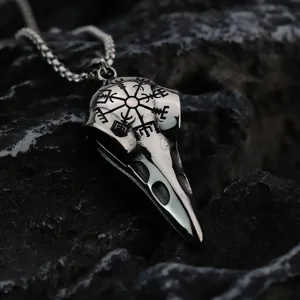 Gros plan d'un collier pendentif crâne de corbeau Viking vintage avec détails de runes.