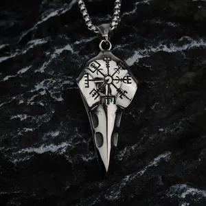 Gros plan d'un collier pendentif tête de corbeau Viking en acier avec gravure boussole.