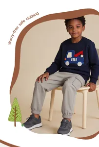 Detailopname van een jonge jongen in stijlvolle grijze cargobroek en een blauwe sweater.