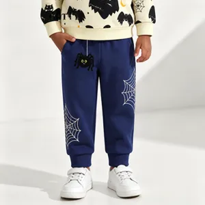 Close-up detail of kids cuffed sweatpants with cute spider web graphic and soft cotton fabric.