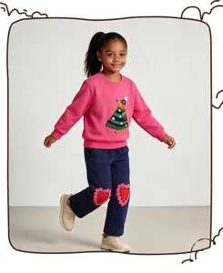 Detailed view of children's pink sweatshirt and navy sweatpants set featuring festive appliques.