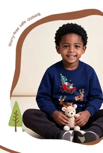 Close-up van de blauwe kinderkersttrui met feestelijke rendierprint en schattig pluche speelgoed.
