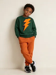 Boys green lightning print sweatshirt and orange sweatpants set, comfortable knit cotton top.