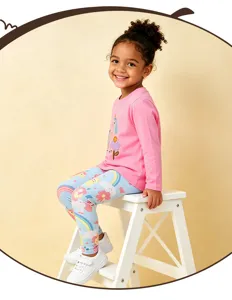 Vista detallada del conjunto de camiseta rosa con unicornio y leggings con estampado de arcoíris.