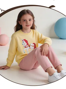 Detailed shot of kids yellow sweatshirt featuring cute unicorn embroidery and soft pink pants.