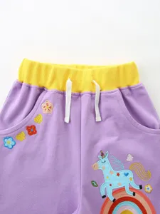 Süße Kleinkind Mädchen lila Shorts mit Einhorn Stickerei und gelbem Taillenbund.
