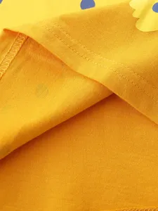 Bright yellow kids short sleeve t-shirt fabric detail with cute blue dot patterns.