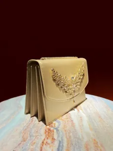 Nahaufnahme des luxuriösen goldenen Abendtaschen-Flügeldetails mit Strasssteinen.