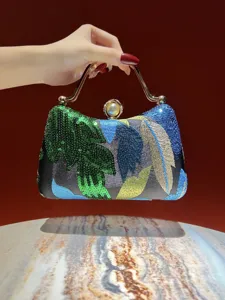 Detailed view of luxury sequin embroidered evening clutch bag with metal handle and pearl clasp.