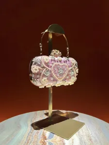 Detailaufnahme der rosa Satin Abendtasche mit zarten Perlen und funkelnden Strasssteinen.