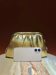 Golden metallic gathered clutch bag detail view, shiny evening purse with metal frame.