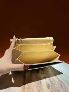 Vue détaillée du sac de soirée jaune à chaîne et soufflets multiples, élégante pochette.