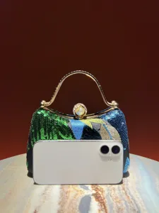 Close-up detail view of vintage luxury sequin embroidered evening bag with gold metal handle.